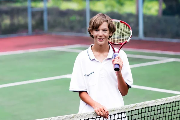 Enfant jouant au tennis sur un court extérieur — Photo