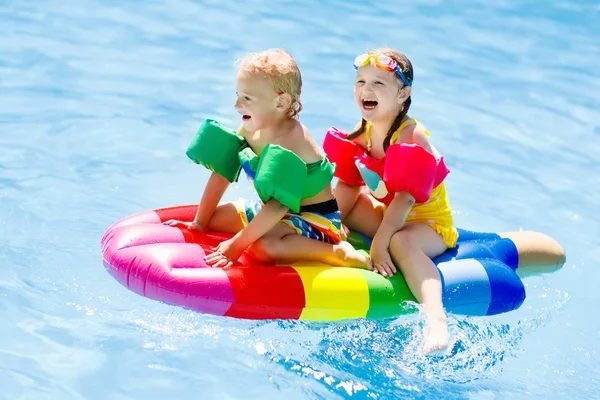 Kinderen op opblaasbare float in zwembad. — Stockfoto