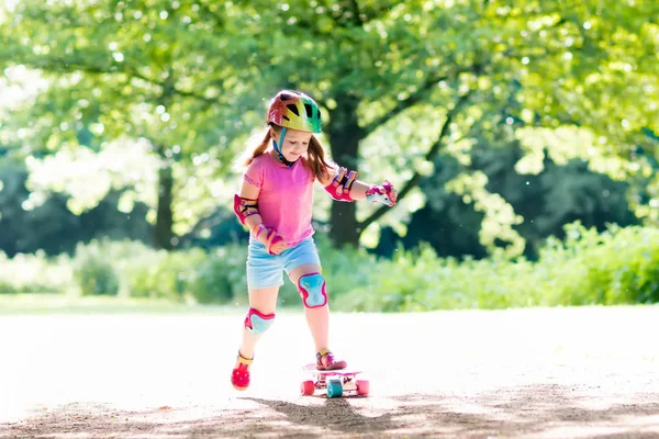 Børne ridning skateboard i sommerpark - Stock-foto