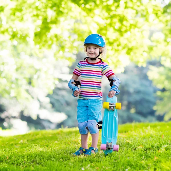 Child riding skateboard in summer park — Stock Photo, Image