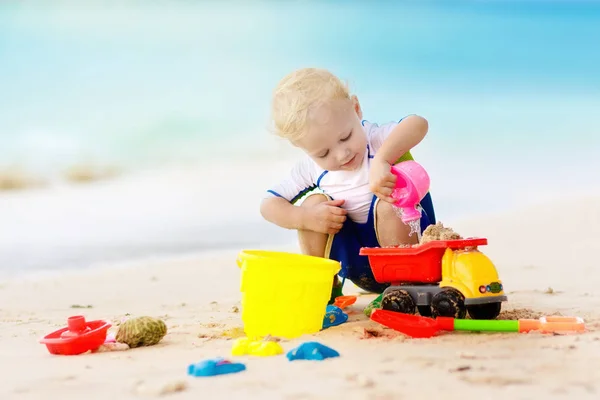 Çocuklar tropik sahilde oynar. Kum ve su oyuncak. — Stok fotoğraf