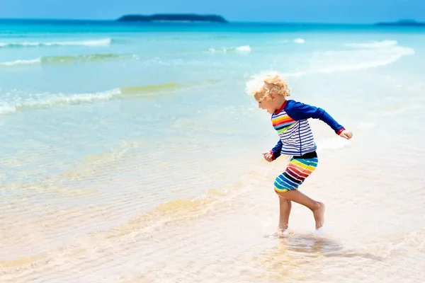 เด็กบนชายหาดเขตร้อน ทะเลวันหยุดกับเด็ก . — ภาพถ่ายสต็อก