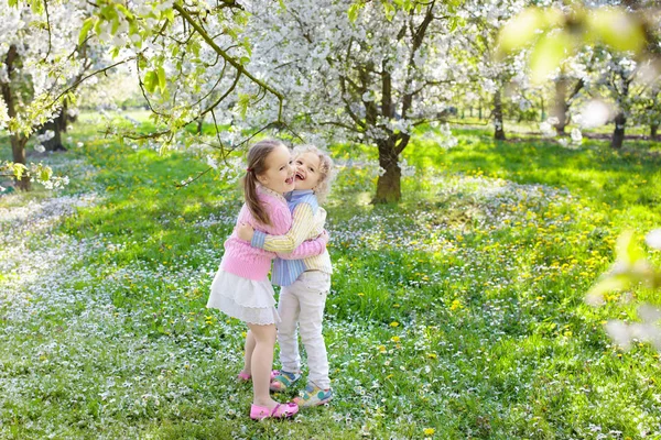 Kinder mit Kirschblütenblume. Ostereiersuche. — Stockfoto