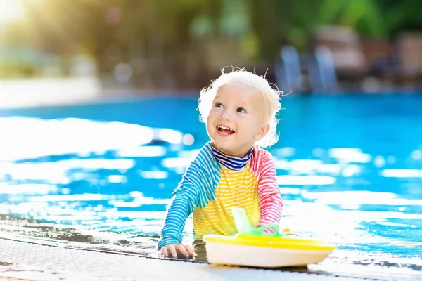 Baby in swimming pool. Family summer vacation.