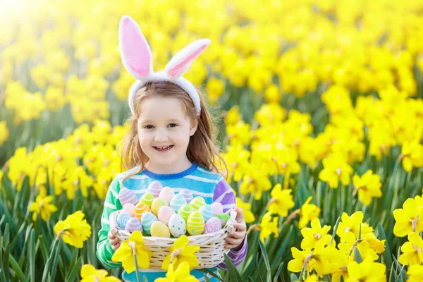 Kind met bunny oren op Easter egg hunt — Stockfoto