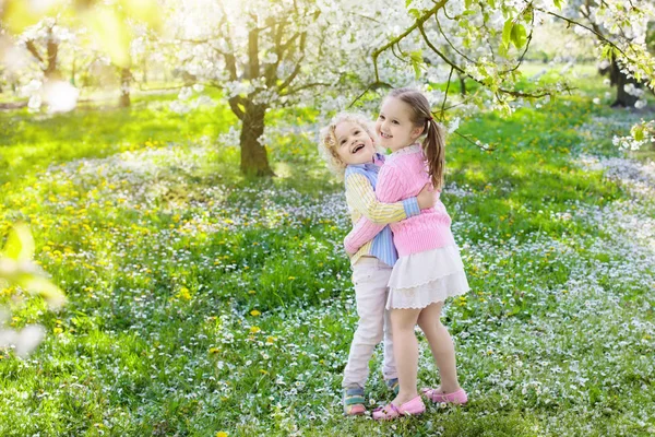 Niños con flor de cerezo. Caza de huevos . — Foto de Stock