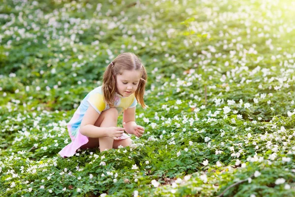 Ребёнок в весеннем парке с цветами — стоковое фото