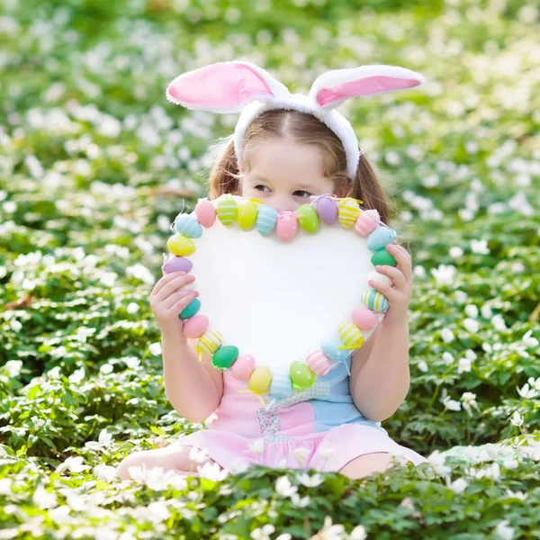 Bambini con orecchie da coniglio a caccia di uova di Pasqua . — Foto Stock