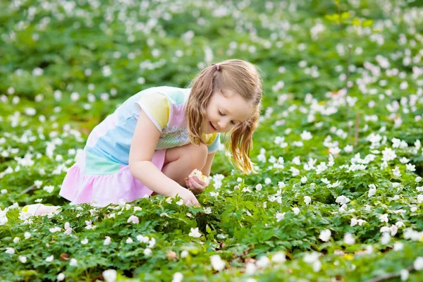 Niño en el parque de primavera con flores — Foto de Stock