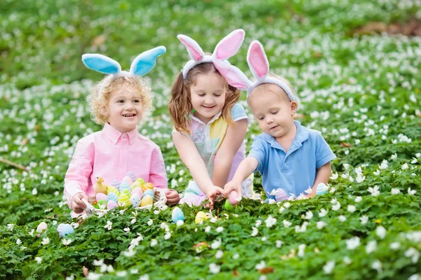 Kids with bunny ears on Easter egg hunt. — Stock Photo, Image