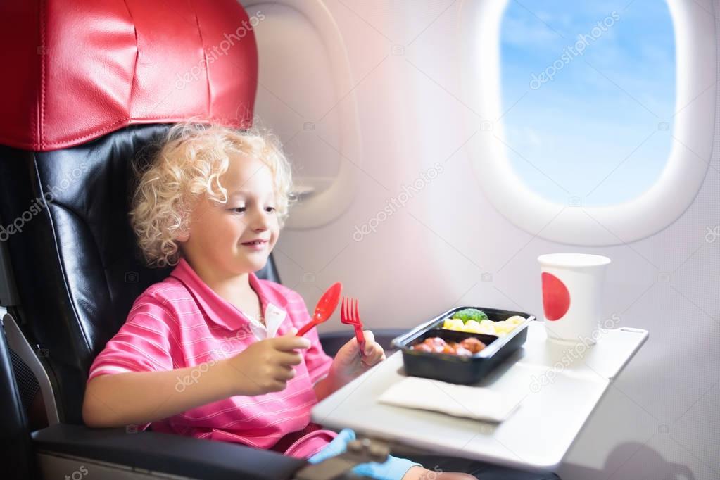 Child in airplane. Kids fly. Children flight meal