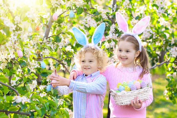 Easter egg hunt. Kids with bunny ears and basket. — Stock Photo, Image