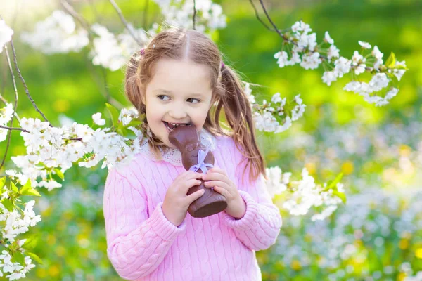 Kinder auf Ostereiersuche im blühenden Garten. — Stockfoto