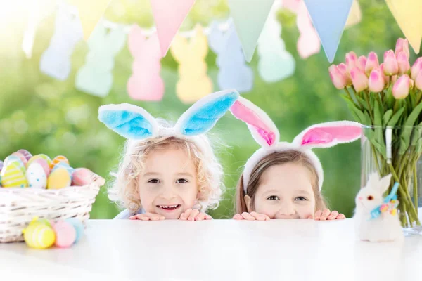 Kinderen met bunny oren en eieren op Easter egg hunt. — Stockfoto