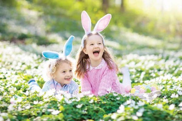 Dzieci z bunny uszy na Easter egg hunt. — Zdjęcie stockowe
