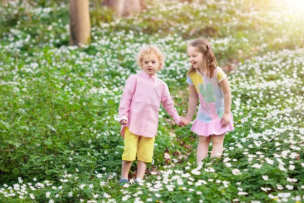 Niños en el parque de primavera con flores — Foto de Stock
