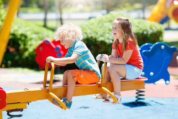 Bambini al parco giochi. I bambini giocano nel parco estivo . — Foto Stock