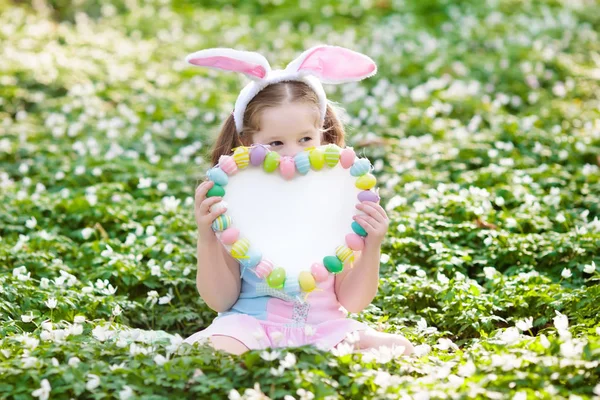 Crianças com orelhas de coelho na caça ao ovo de Páscoa . — Fotografia de Stock