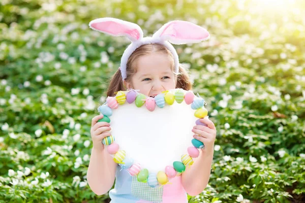 Niños con orejas de conejo en la búsqueda de huevos de Pascua . — Foto de Stock