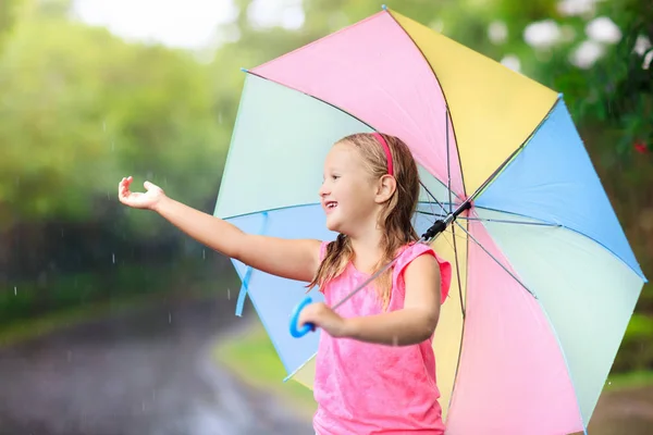 Niño con paraguas jugando bajo la lluvia de verano . — Foto de Stock