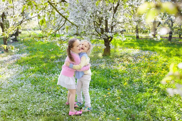 Dzieci z wiśni kwiat kwiat. Easter egg hunt. — Zdjęcie stockowe