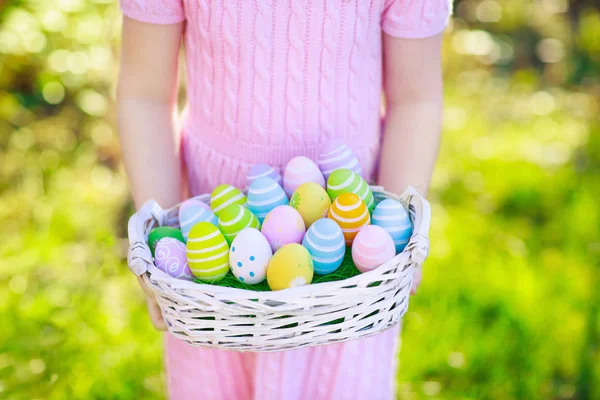 Crianças na caça ao ovo de Páscoa com cesta de ovos . — Fotografia de Stock
