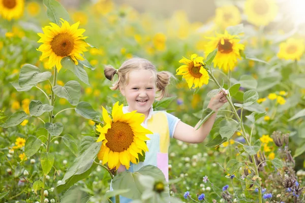 Kind in zonnebloem veld. Kinderen met zonnebloemen. — Stockfoto