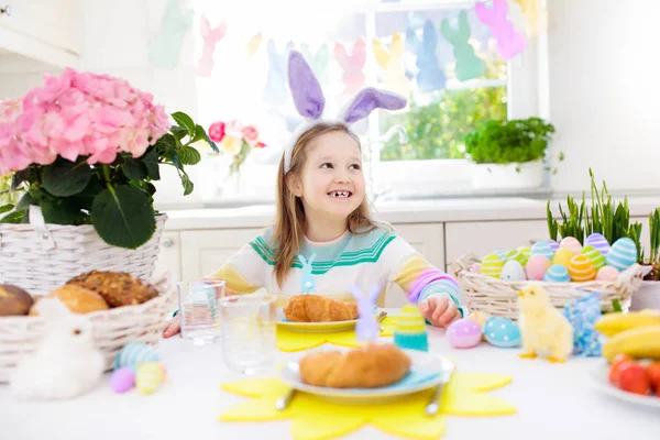 Kids at Easter breakfast. Eggs basket, bunny ears. — Stock Photo, Image