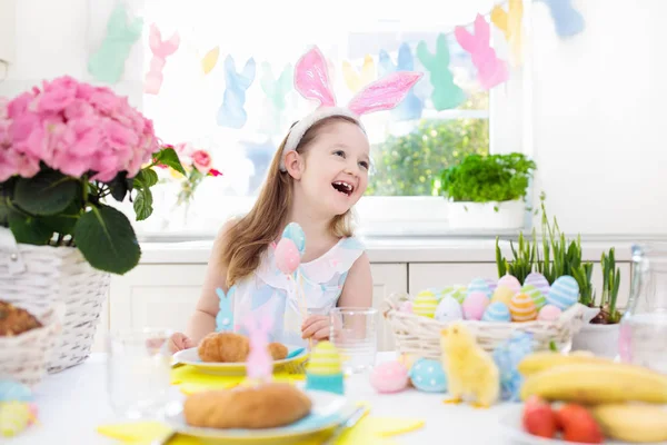 Niños en el desayuno de Pascua. Cesta de huevos, orejas de conejo . —  Fotos de Stock