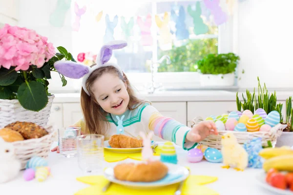 Kids at Easter breakfast. Eggs basket, bunny ears. — Stock Photo, Image