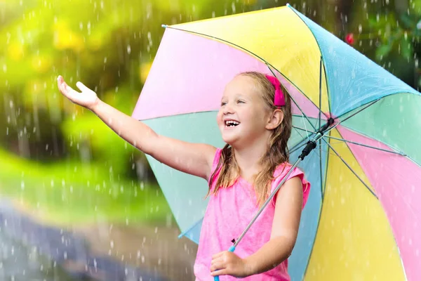 Kid with umbrella playing in summer rain. — Stock Photo, Image