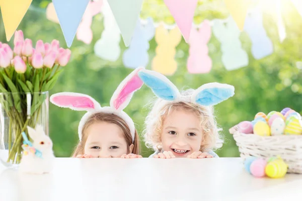 Dzieci z bunny uszy i jaj na Easter egg hunt. — Zdjęcie stockowe
