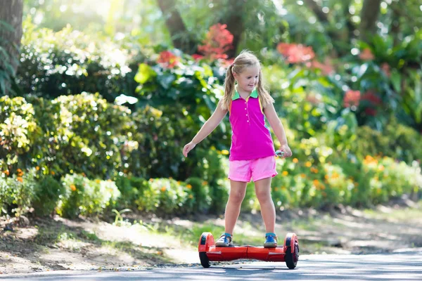 Criança a bordo. Crianças andar de scooter . — Fotografia de Stock