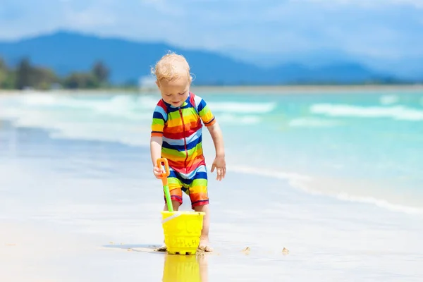 As crianças brincam na praia tropical. Brinquedo de areia e água . — Fotografia de Stock