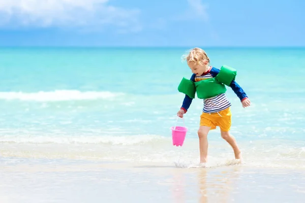 子供たちは、熱帯のビーチで遊ぶ。砂と水のグッズ. — ストック写真