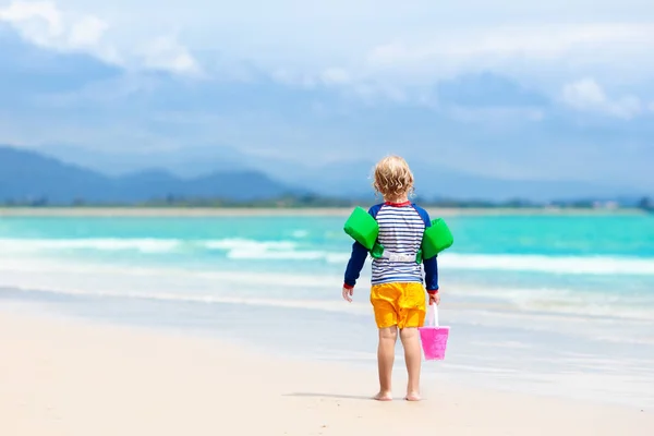 子供たちは、熱帯のビーチで遊ぶ。砂と水のグッズ. — ストック写真