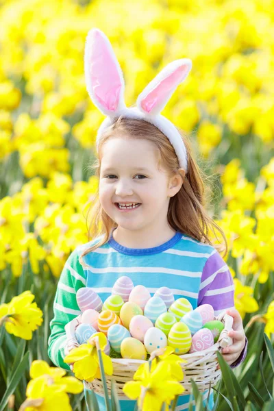 Niño con orejas de conejo en la búsqueda de huevos de Pascua — Foto de Stock