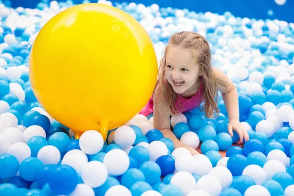 As crianças jogam em um poço de bolas. Criança brincando na piscina bolas — Fotografia de Stock