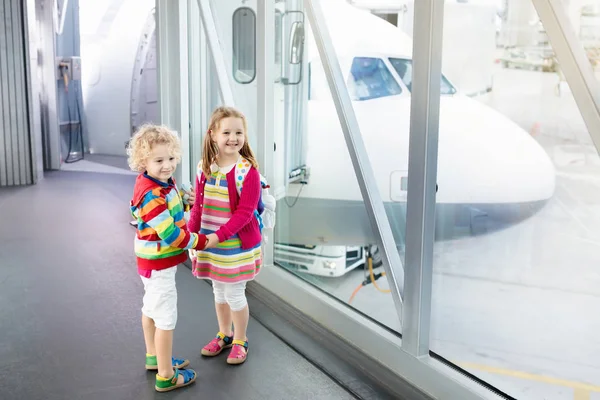 Los niños viajan y vuelan. Niño en el avión en el aeropuerto — Foto de Stock