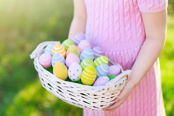 Niños en la búsqueda de huevos de Pascua con cesta de huevos . —  Fotos de Stock