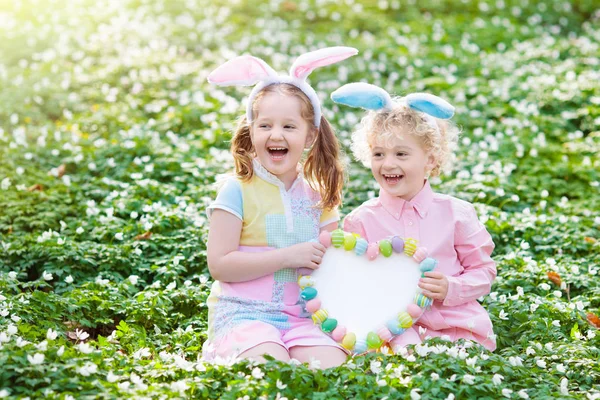 Kids with bunny ears on Easter egg hunt. — Stock Photo, Image