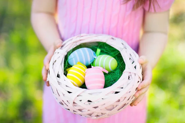 Niños en la búsqueda de huevos de Pascua con cesta de huevos . — Foto de Stock