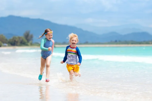 Niños en la playa tropical. Niños jugando en el mar . —  Fotos de Stock