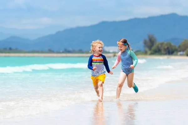 Çocuklar tropik sahilde. Çocuklar denizde oyun. — Stok fotoğraf