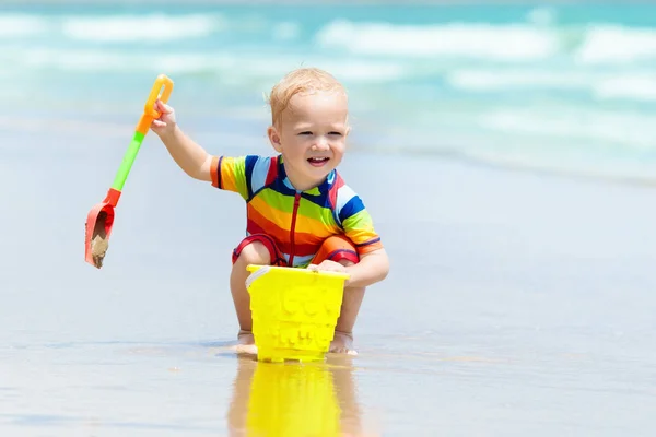 Dzieci grają na tropikalnej plaży. Zabawki do piasku i wody. — Zdjęcie stockowe