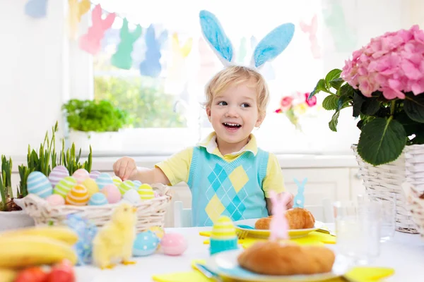 Kids at Easter breakfast. Eggs basket, bunny ears. — Stock Photo, Image