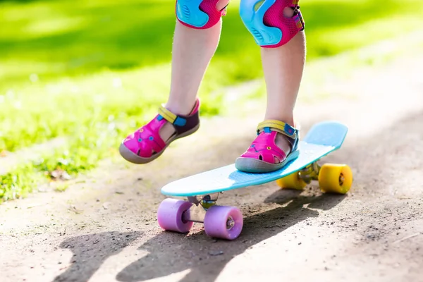 Child riding skateboard in summer park — Stock Photo, Image