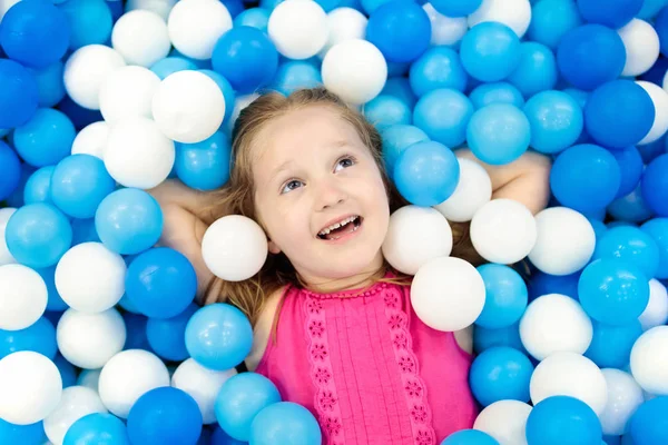 As crianças jogam em um poço de bolas. Criança brincando na piscina bolas — Fotografia de Stock