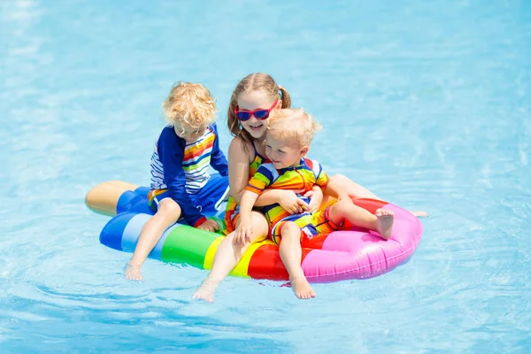 Bambini su galleggiante gonfiabile in piscina . — Foto Stock