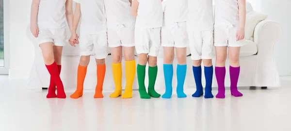 Τα παιδιά με πολύχρωμες κάλτσες. Παιδικά υποδήματα. — Φωτογραφία Αρχείου